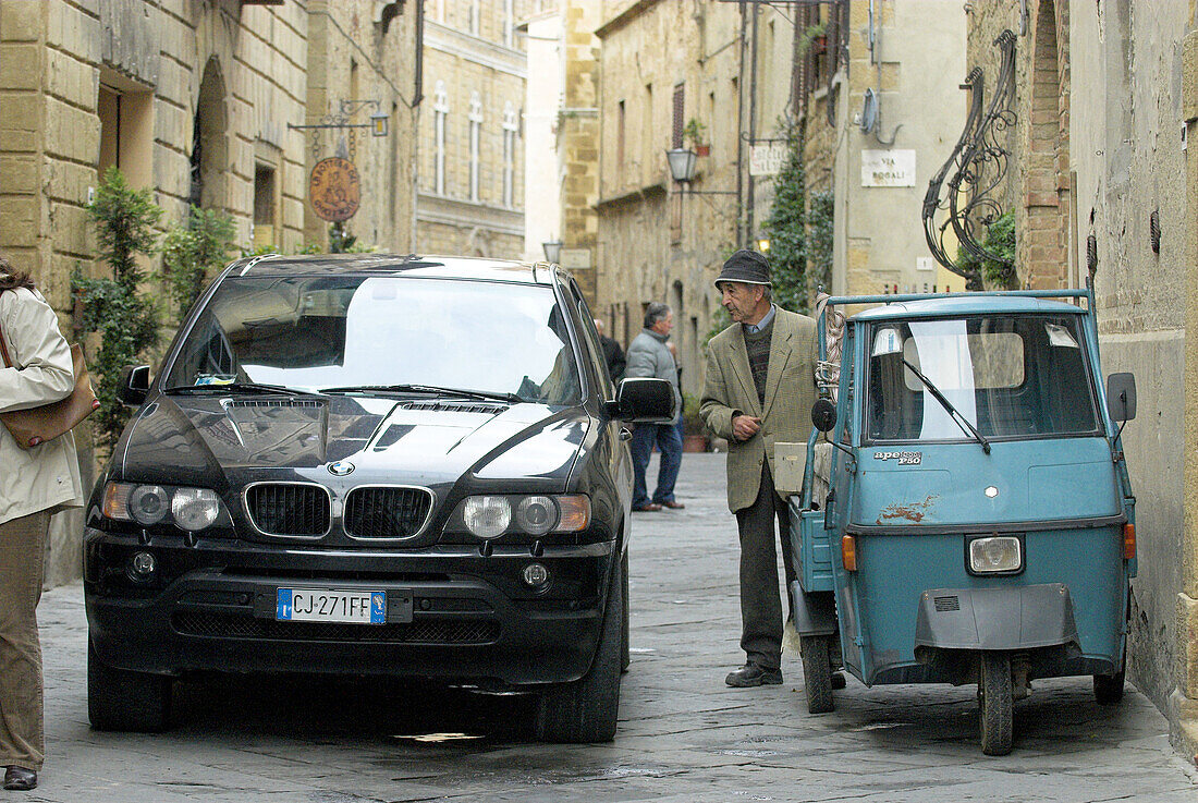 Pienza, Viale Rossellino, narrow lane, modern and traditional vehicles, de luxe car and three wheeler, Tuscany, Italy