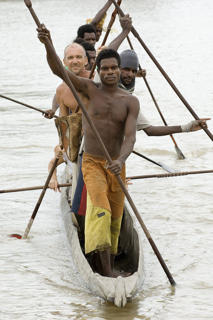 Group of men paddling dug out, Indonesia