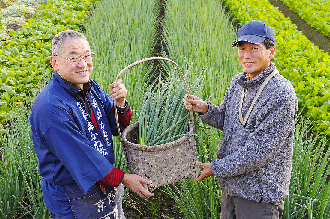 Farmers showing a basket with onionplant, smiling, portrait, Japan