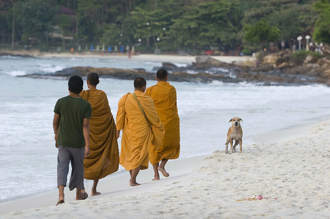 Buddhist monks walking on the beach early morning in Ko Samet, Thailand
