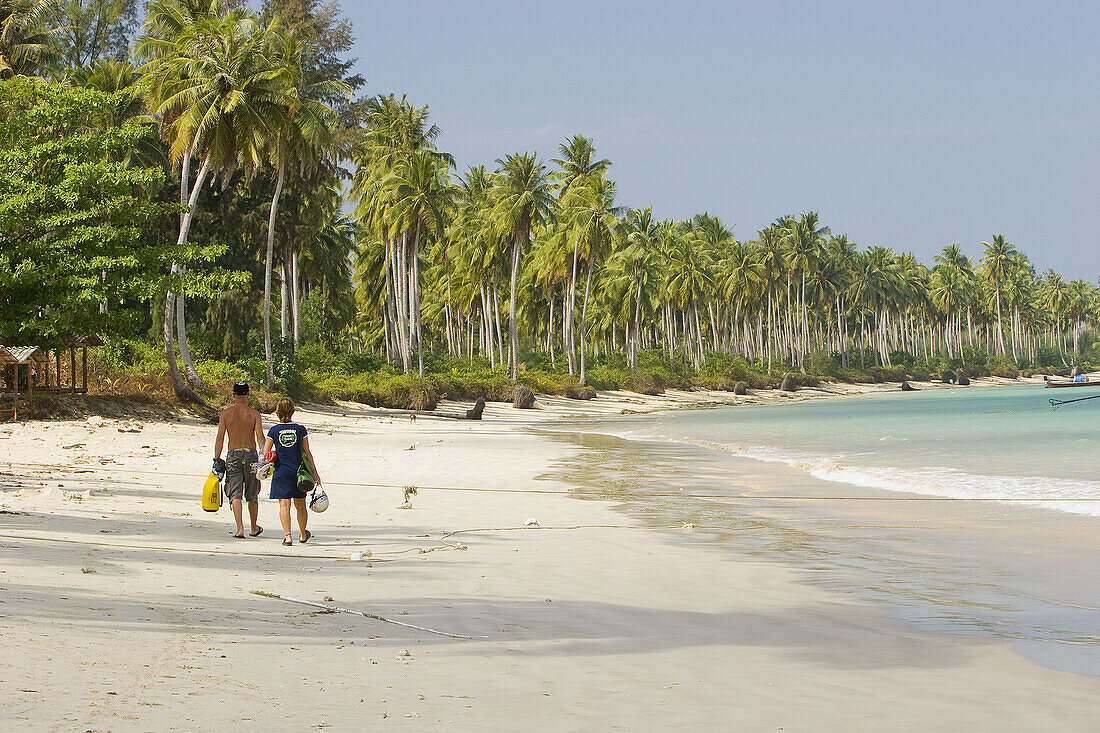A couple walking on Khao Lak Beach, Thailand