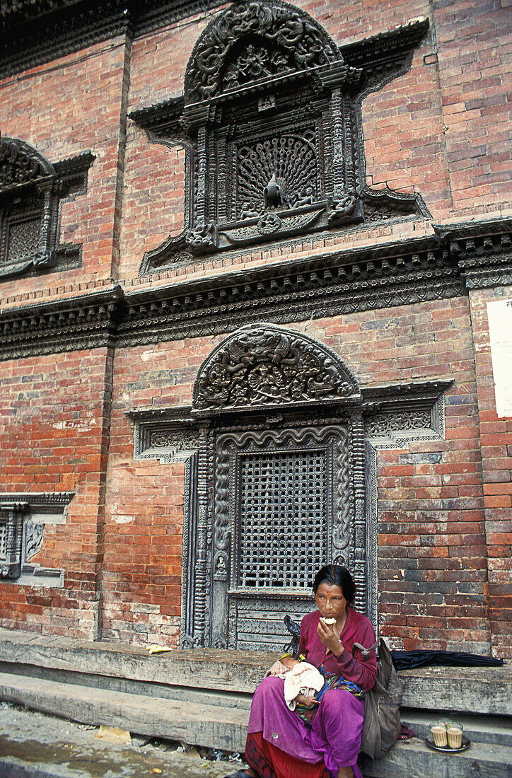 A local nepali woman rests in one of the old streets of Patan, Kathmandu valley, Nepal