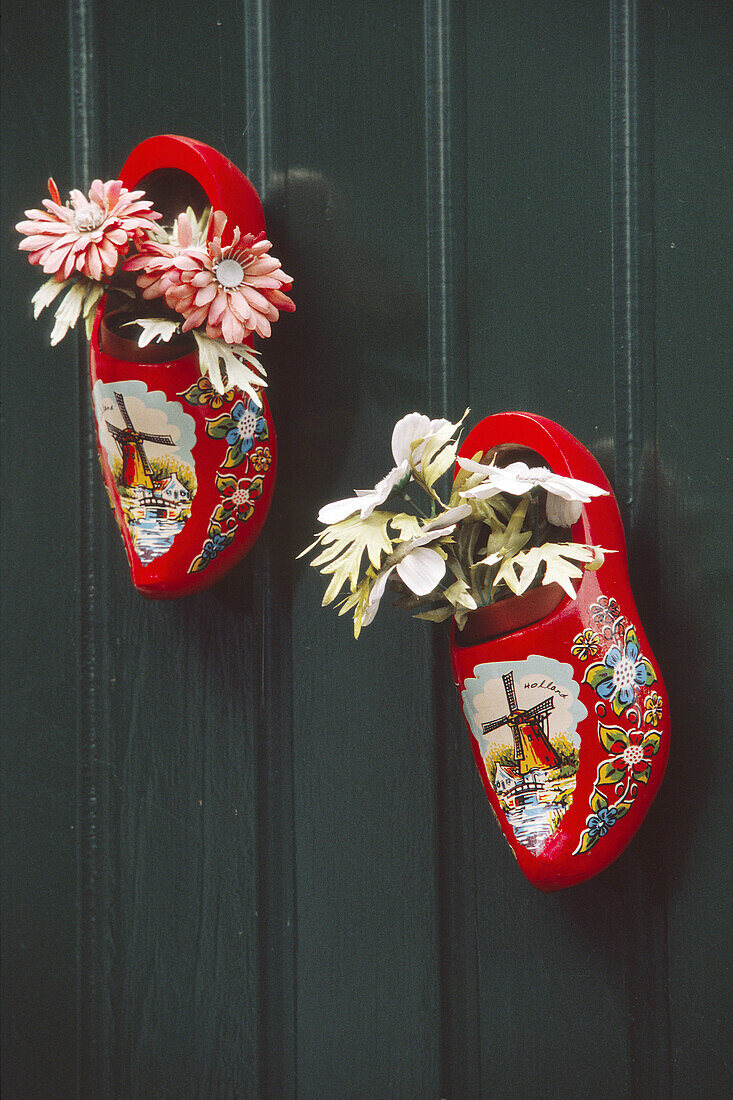 Netherlands, Marken, Fishing village, Pair of decorated red clogs filled with flower