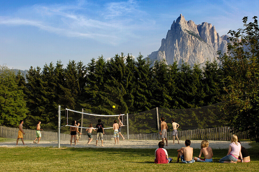Teenagers playing volleyball in the sunlight, Kastelruth Seis, Telfen, South Tyrol, Italy, Europe