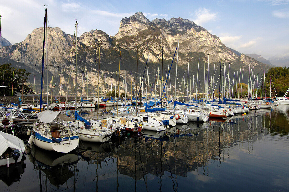 Boats at marina in front of mountains in the sunlight, Garda lake, Italy, Europe