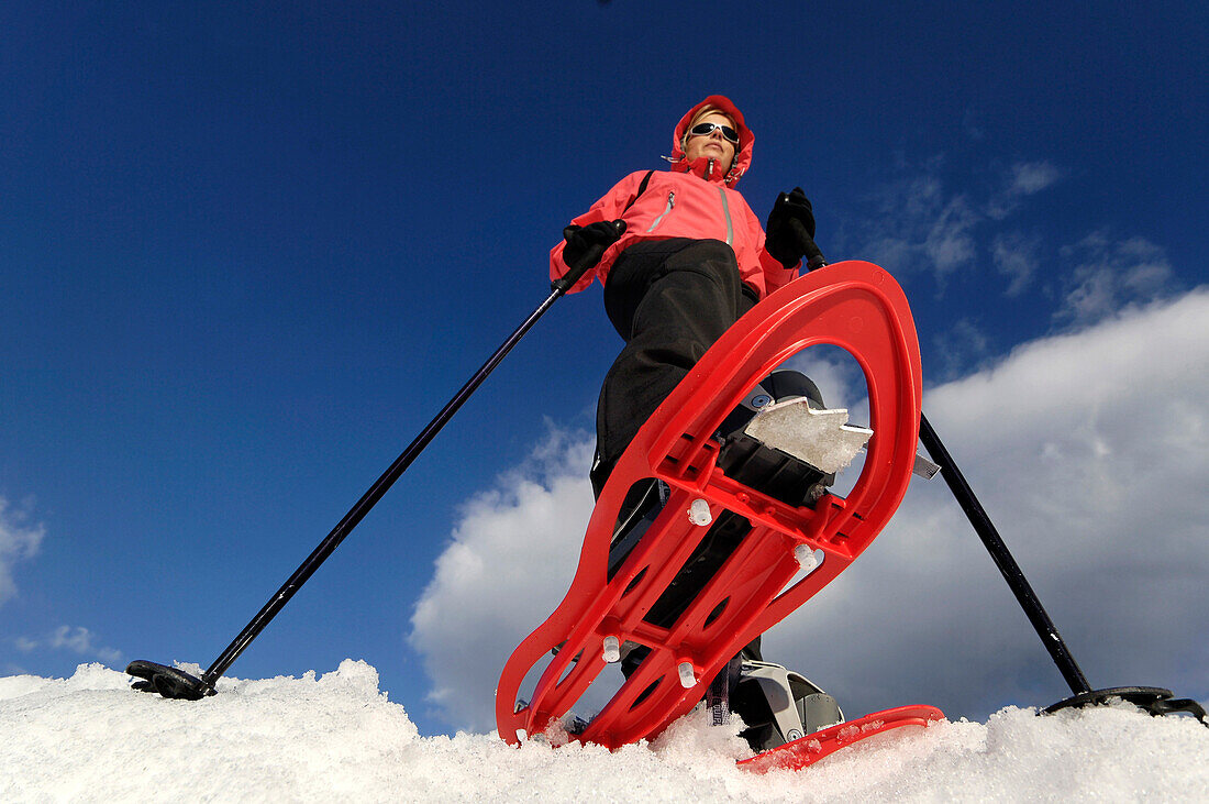 A woman snowshoeing in the sunlight, Schnals valley, Val Venosta, South Tyrol, Italy, Europe