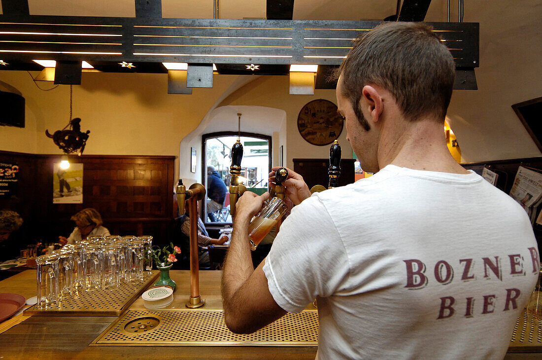 Der Barmann hinter der Theke der Brauerei Hopfen & Co., Bozen, Südtirol, Italien, Europa