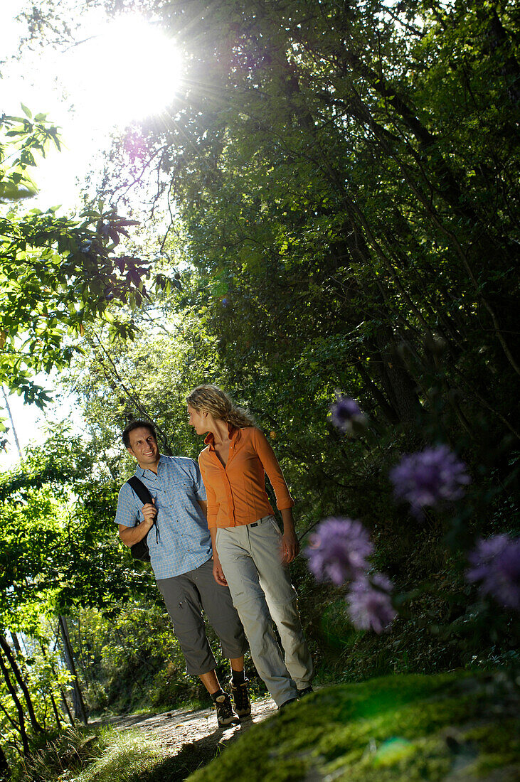 Ein junges Paar wandert im Sommer im Wald, Vinschgau, Südtirol, Italien, Europa