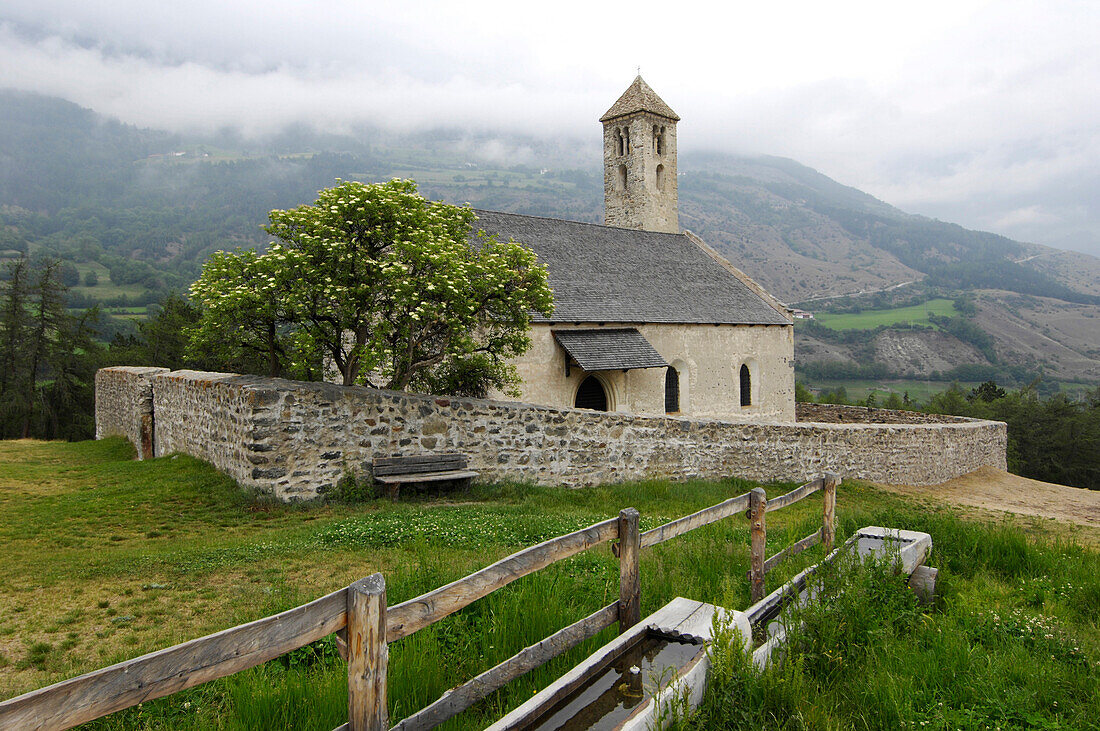 Blick auf die Kirche St. Veit im Dorf Tartsch unter Wolken, Tartsch, Vinschgau, Südtirol, Italien, Europa