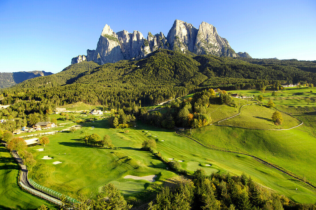 Golf court in the sunlight in front of mountains, Golf court Kastelruth Seiser Alm, Sciliar, South Tyrol, Italy, Europe