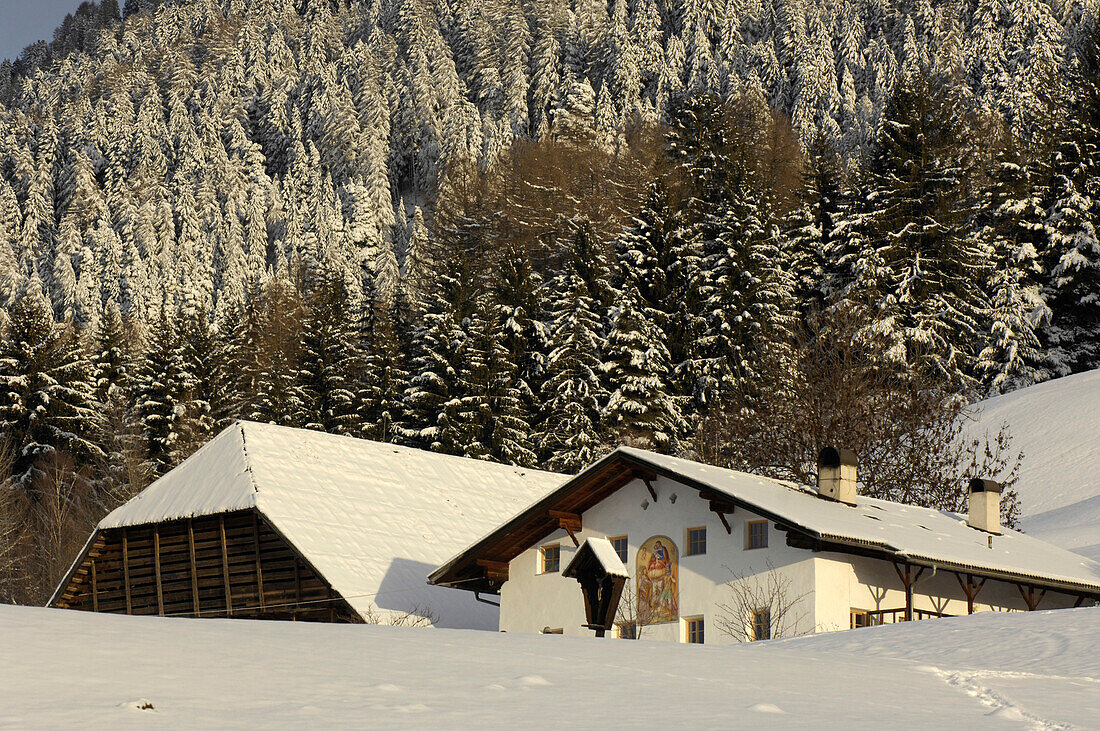 Schneebedecktes Bauenhaus mit Scheune im Sonnenlicht, Kastelruth, Eisacktal, Südtirol, Italien, Europa