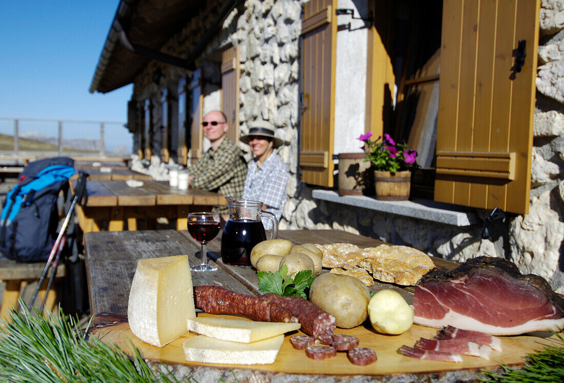 Brotzeit vor einer Almhütte im Sonnenlicht, Seiser Alm, Eisacktal, Südtirol, Italien, Europa