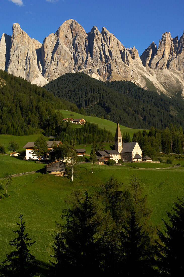 Village of Villnoess with St. Magdalena church, Geislerspsitzen of the Geisler Mountain Range in the background, Villnoess Valley, Dolomites, South Tyrol, Italy