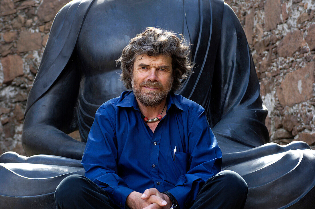 Reinhold Messner vor Buddha Statue, Extrembergsteiger und Buchautor, MMM, Messner Mountain Museum, Südtirol, Italien