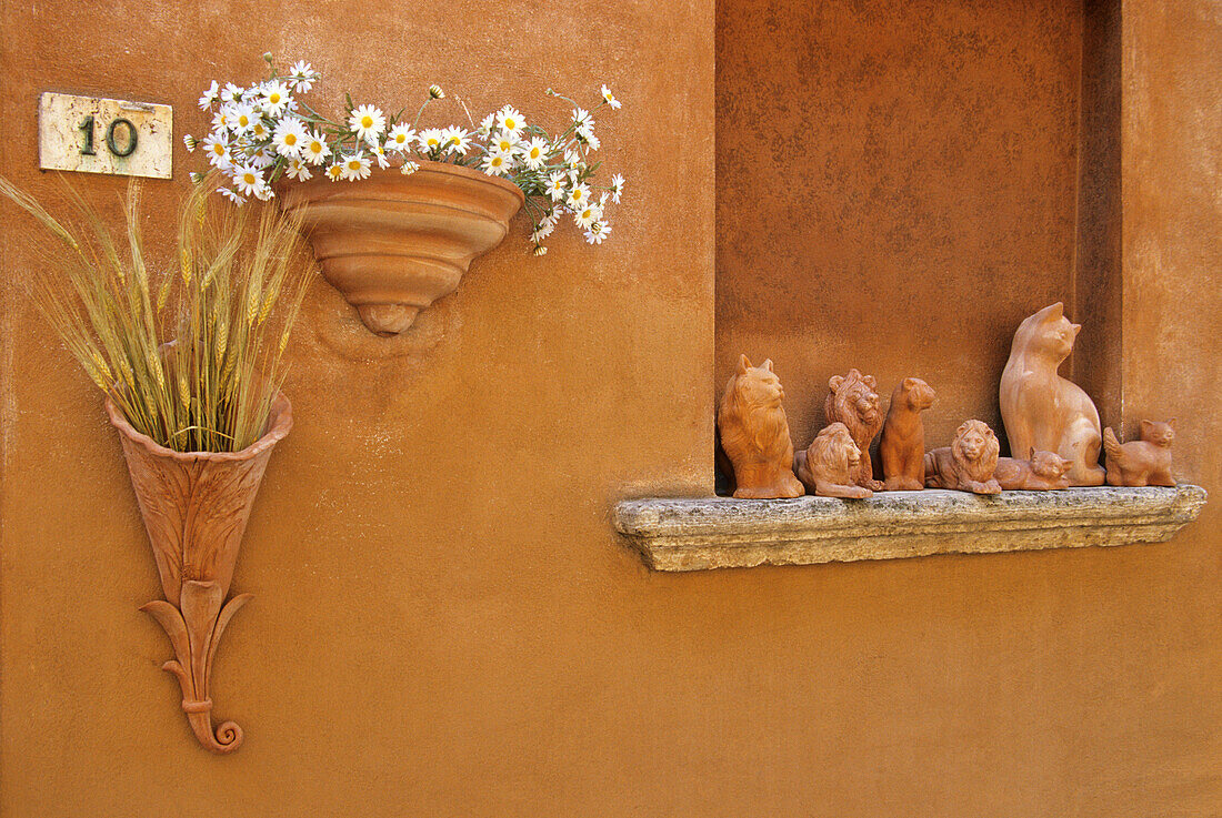 Facade of a house with clay figures, Pitigliano, Tuscany, Italy, Europe