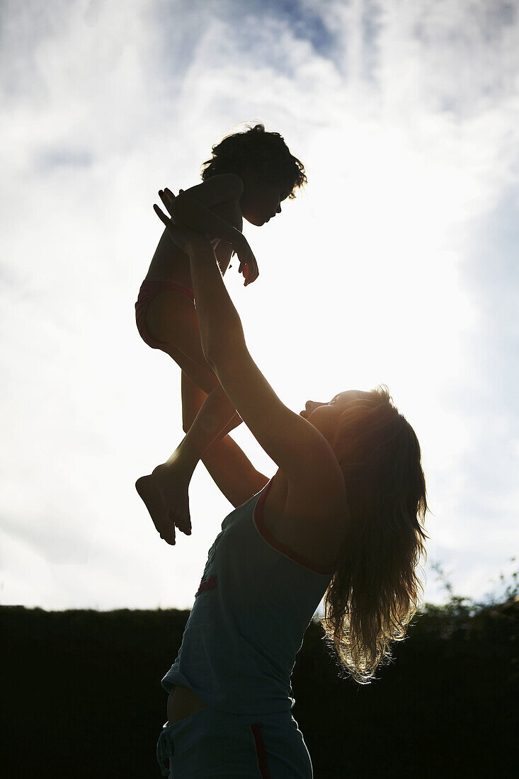 Mother and daughter in backlight.