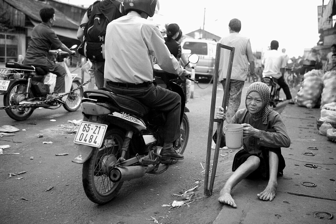 Una mujer invalida pide limosna en la calle, My Tho, Vietnam