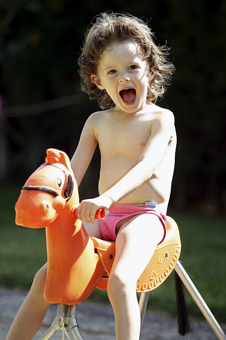 4 year old girl sitting on a rocking horse.