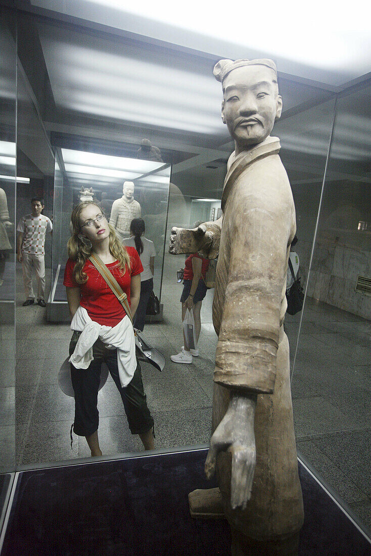 Woman looking at terracotta warrior. Xian City. Shaanxi Province. China.