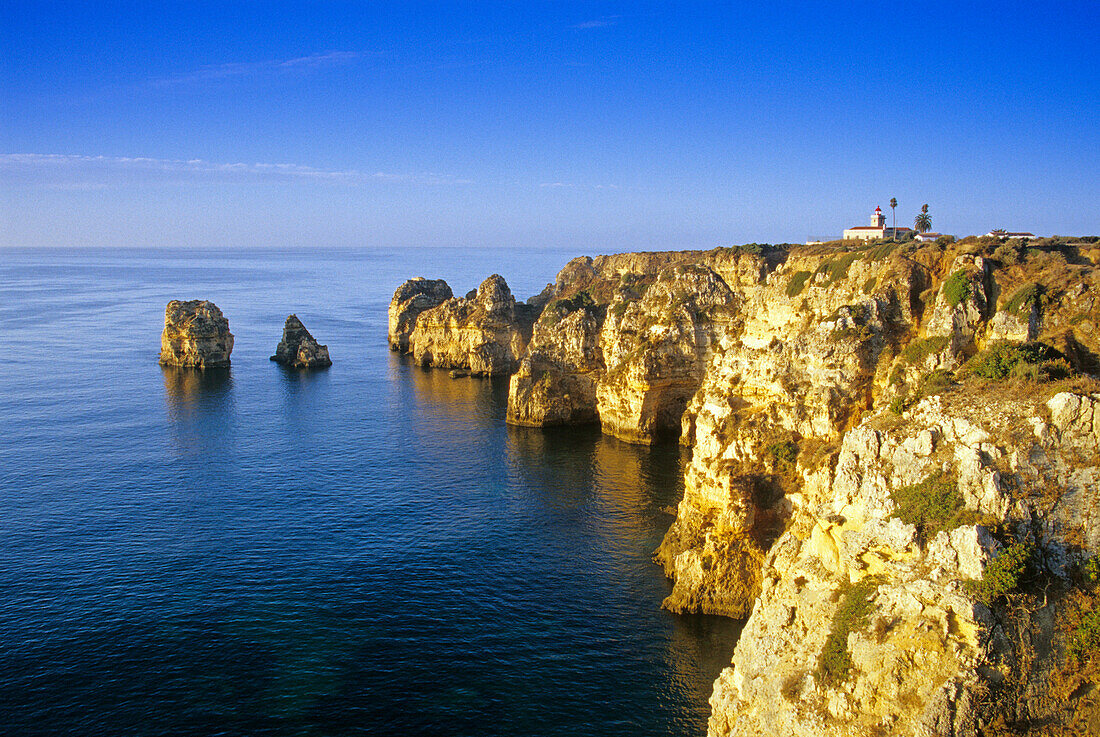 Leuchtturm an der Felsküste unter blauem Himmel, Praia do Carvalho, Algarve, Portugal, Europa