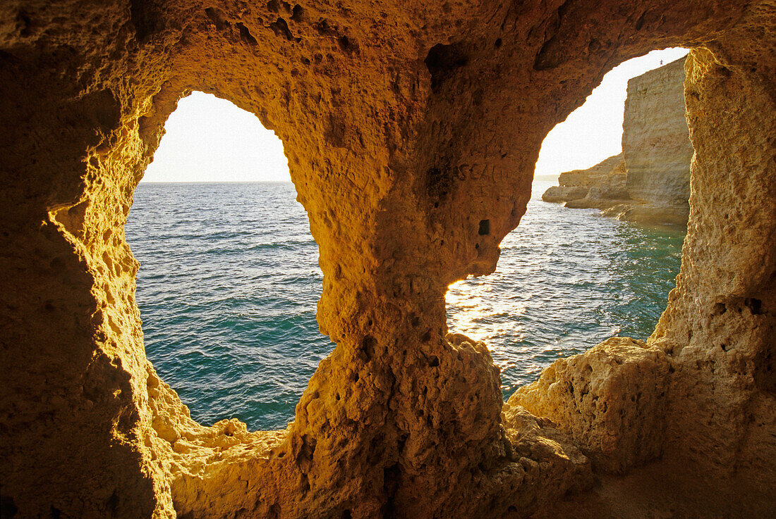 View out of a cave at rocky coast to the ocean, Algar Seco, Algarve, Portugal, Europe