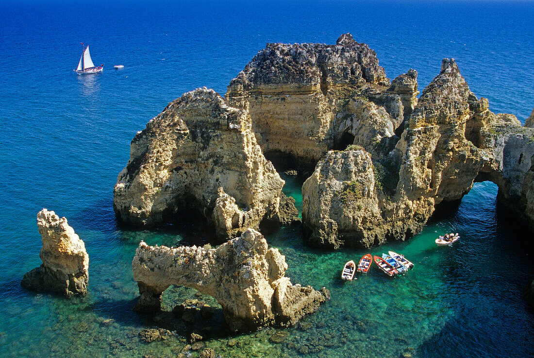 Boats off the rocky coast in the sunlight, Ponta da Piedade, Algarve, Portugal, Europe