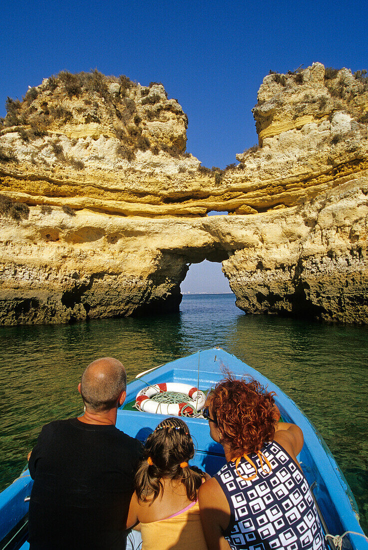 Family in a boat off the rocky coast in the sunlight, Ponta da Piedade, Algarve, Portugal, Europe