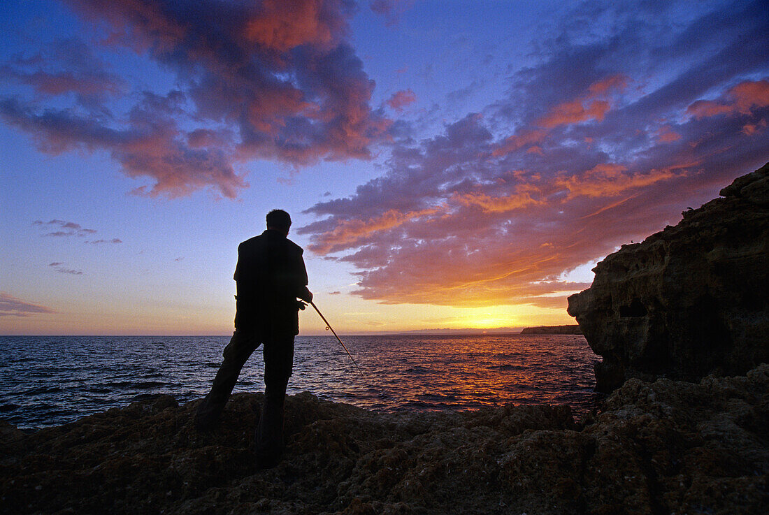 Angler an der Felsküste Algar Seco bei Sonnenuntergang, Algarve, Portugal, Europa