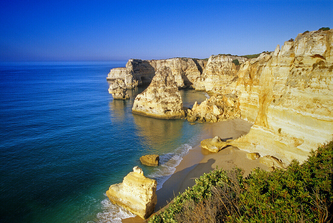 Deserted beach and rocky coast in the sunlight, Praia da Marinha, Algarve, Portugal, Europe