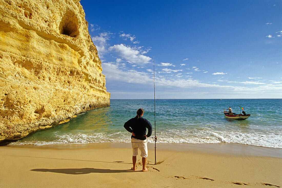 Angler on the beach under blue sky, Praia da Marinha, Algarve, Portugal, Europe