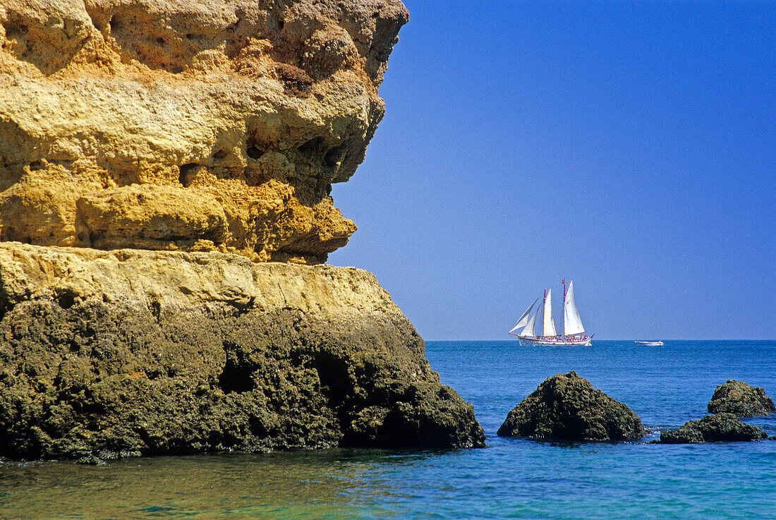 Sailing ship off the rocky coast under blue sky, Praia do Camilo, Algarve, Portugal, Europe