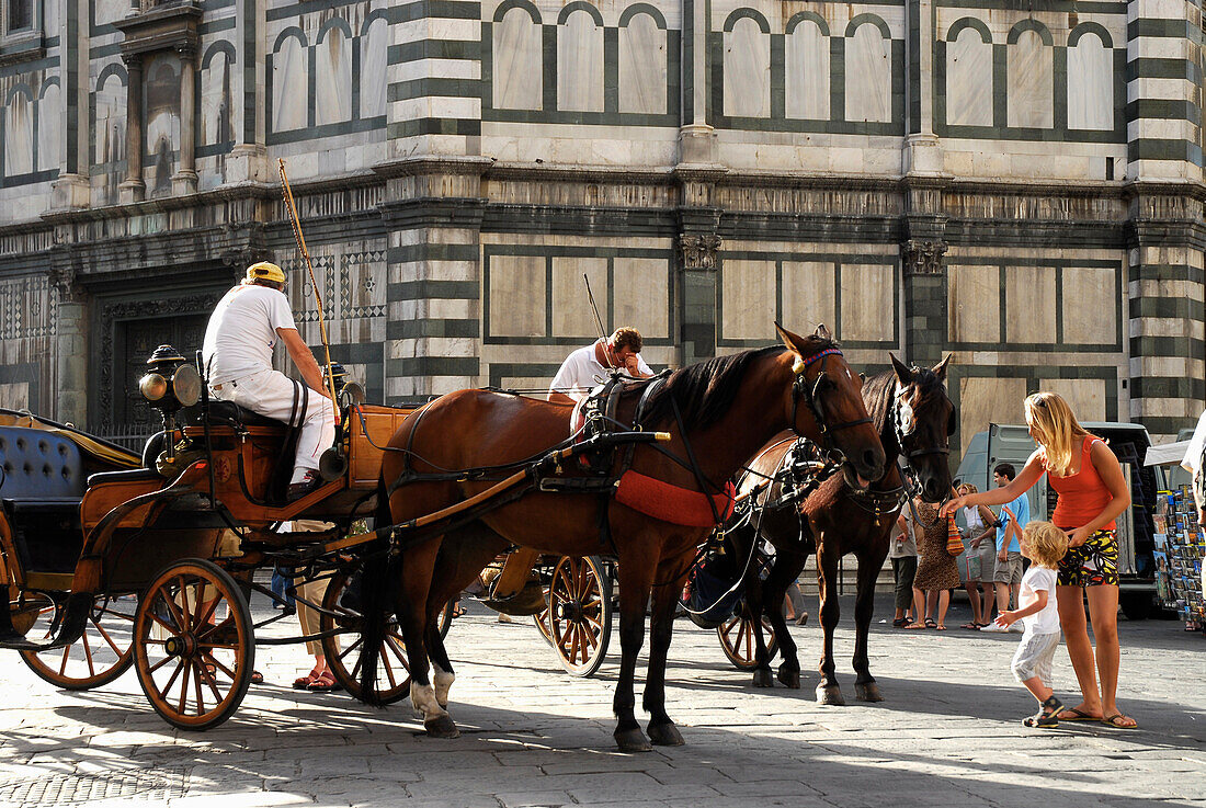 Pferdekutschen und Frau mit Kind vor dem Baptisterium San Giovanni, Florenz, Toskana, Italien, Europa