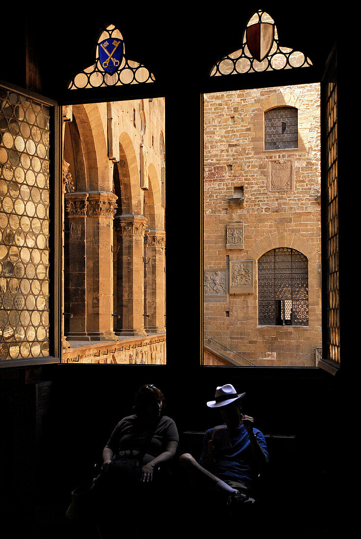 Museo Nazionale del Bargello, window to the courtyard and two tourists sitting in the shadow, Florence, Tuscany, Italy, Europe