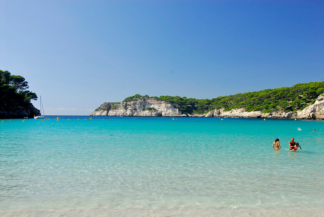 People swimming in the sea, sandy beach and turquoise sea at Cala Galdana, Menorca, Balearics, Spain