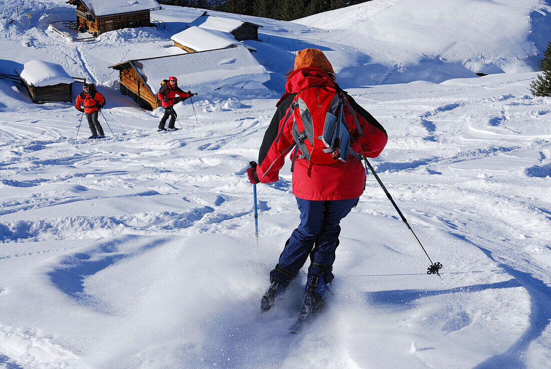 Woman downhill skiing, alpine lodge in background, Feldalpenhorn, Kitzbuehel Alps, Tyrol, Austria