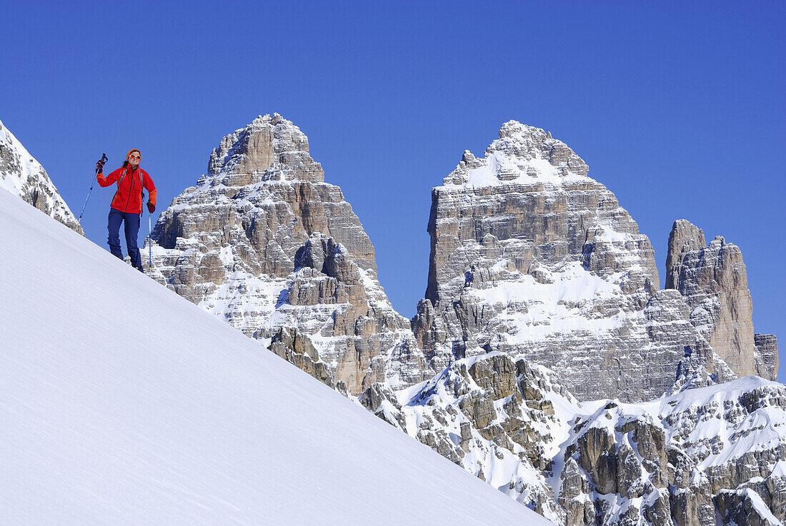 Frau auf einer Skitour, Drei Zinnen im Hintergrund, Cadinigruppe, Dolomiten, Trentino-Südtirol, Italien