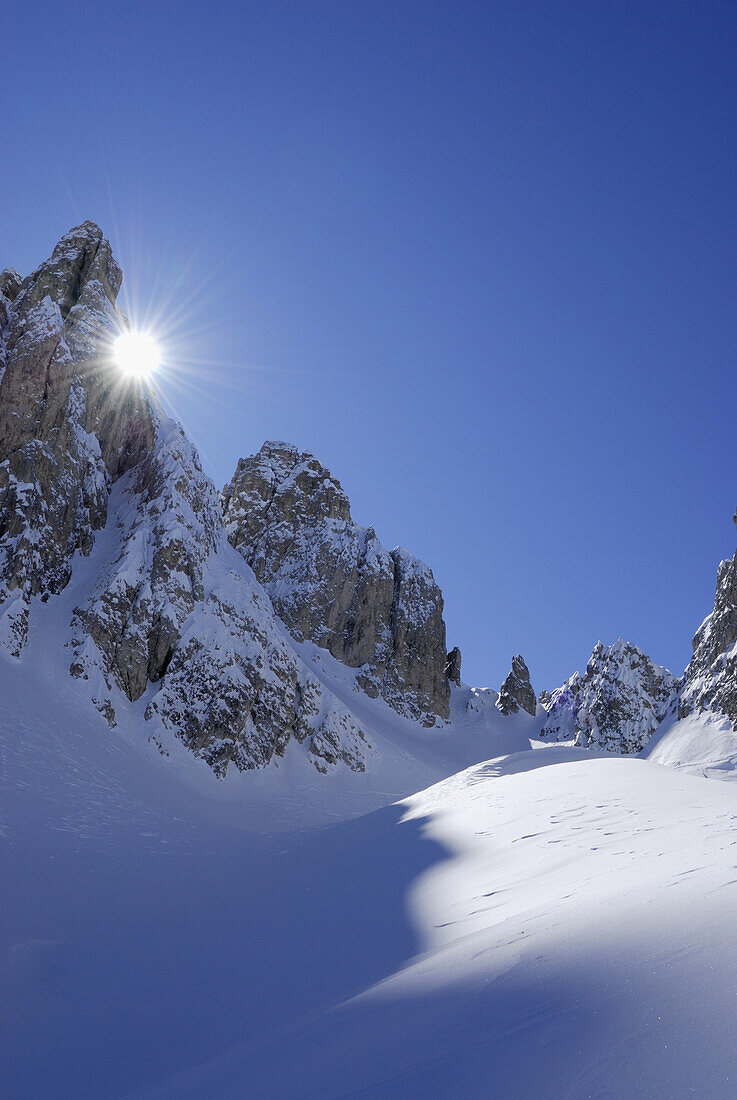 Sonne scheint in winterliches Kar, Cadini-Gruppe, Dolomiten, Trentino-Alto Adige, Italien
