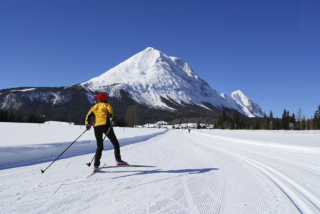 Woman cross-country skiing, Hohe Munde in background, Leutasch, Tyrol, Austria