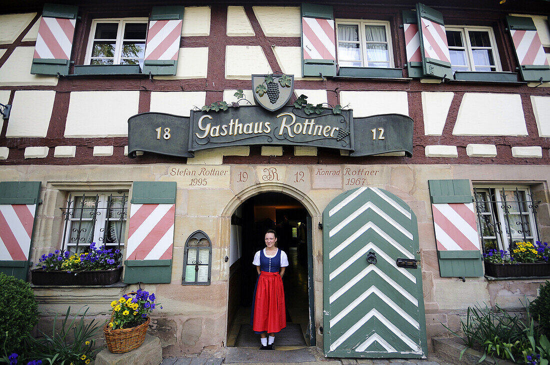 Woman standing in the entrance to restaurant Rottner, Nuremberg, Middle Franconia, Bavaria, Germany