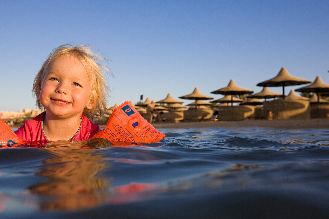 Child, girl, 3, swimming with inflatable armbands in the sea, Lamaya Resort, Coraya, Marsa Alam, Egypt