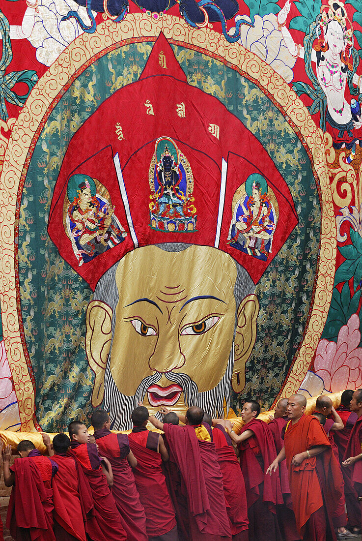 Monks unrolling a huge thangka or thongdrel representing the shabdrung, Bhutan's greatest ruler, punakha tsechu festival, punakha, Bhutan