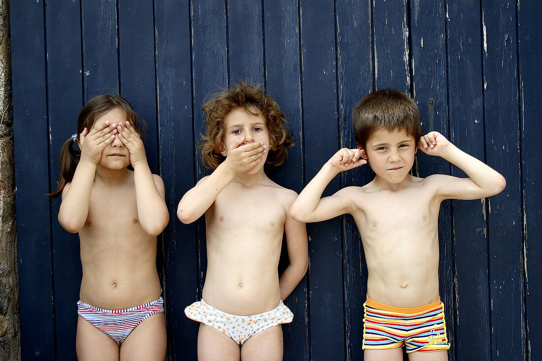 Three children as three wise monkeys