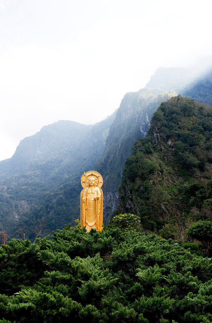 Sonnestrahlen scheinen über die Berge auf die Buddhastatue des Hsiang-Te Tempels, Tienhsiang, Taroko Schlucht, Taroko Nationalpark, Taiwan, Asien