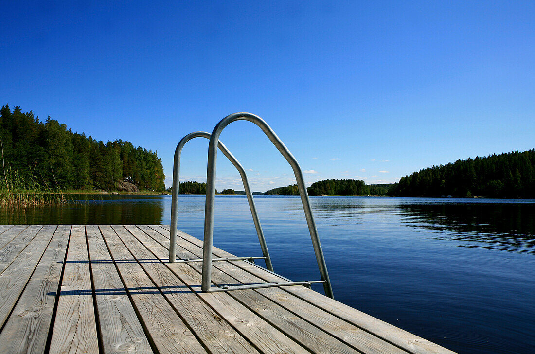 Privater Steg in einer Bucht unter blauem Himmel, Saimaa Seenplatte, Finnland, Europa