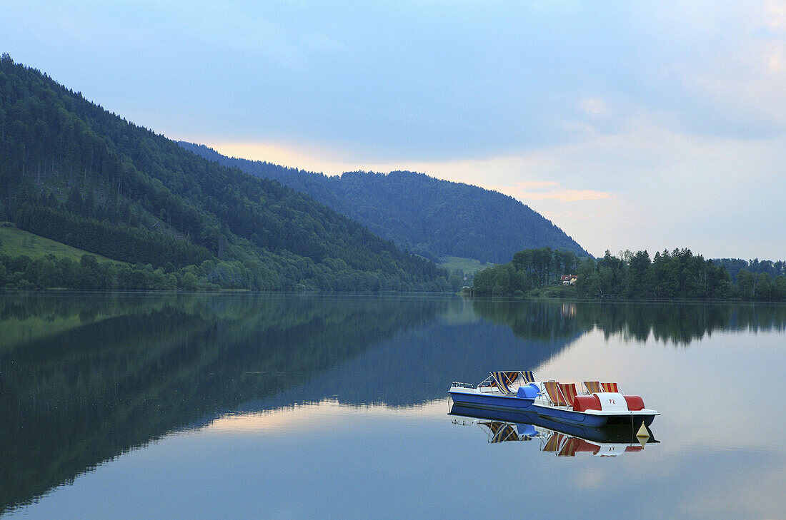 Two deserted pedal boats on lake Schliersee, Bavaria, Germany