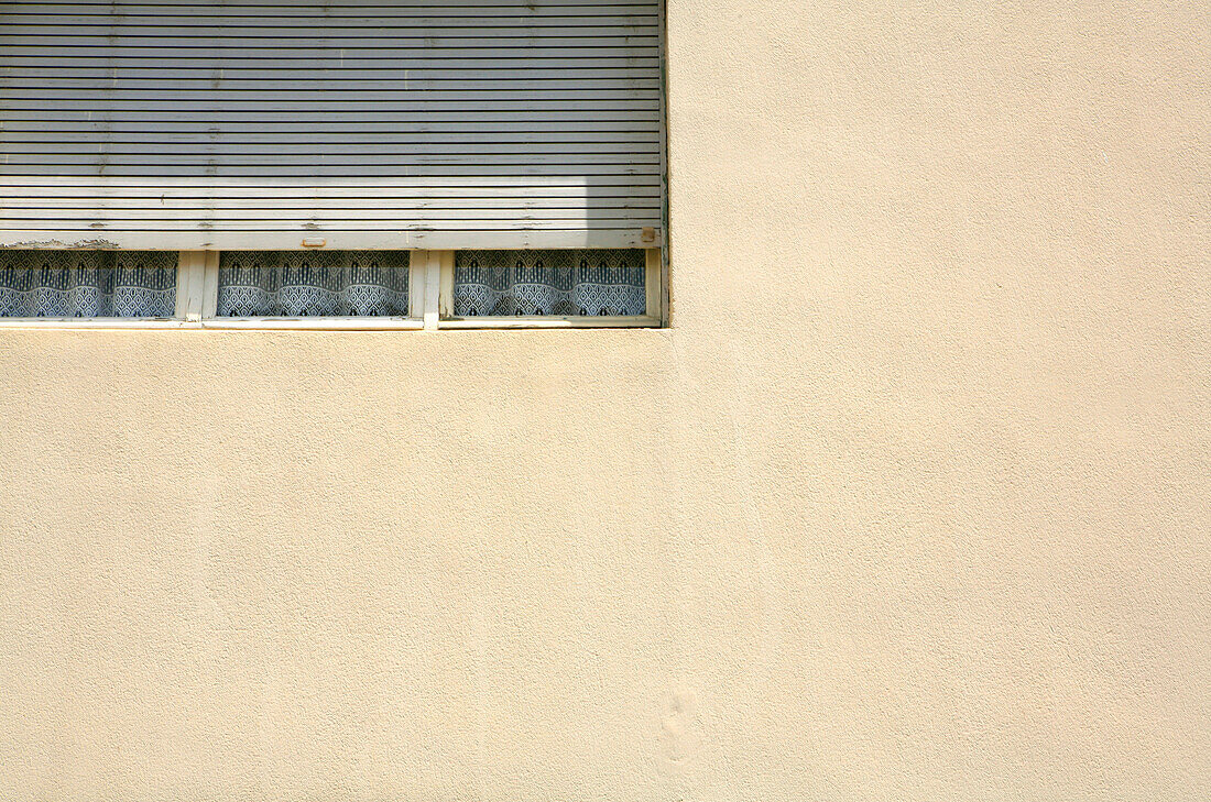 Vorhang hinter fast verschlossener Jalousie in einem Wohnhaus, Arles, Frankreich, Europa