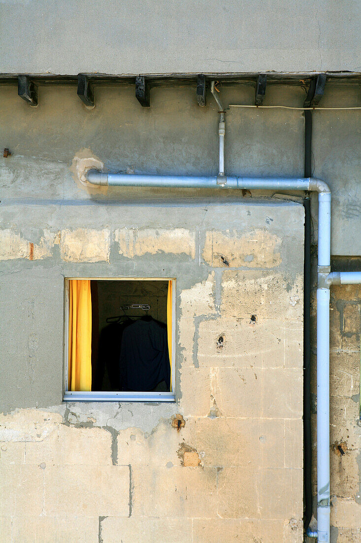 Blick auf ein Fenster mit gelbem Vorhang in einem Wohnhaus, Arles, Frankreich, Europa