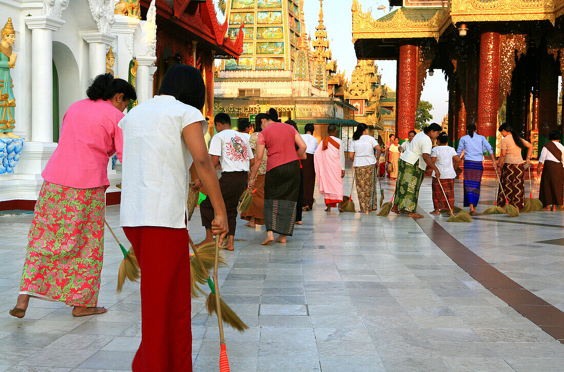 Buddhistic women doing good for their karma sweeping the Shwedagon Pagoda, Rangoon, Myanmar, Burma, Asia
