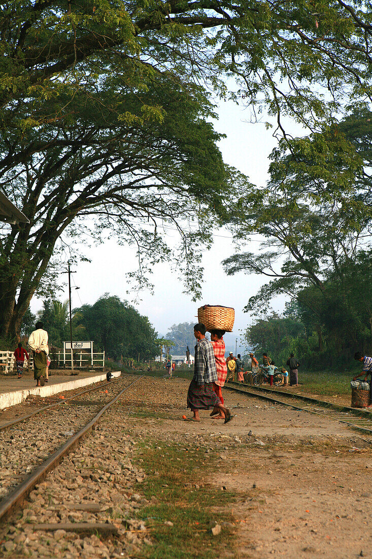 Frauen tragen einen Korb über Bahngleise zum Bahnhof, Hispaw, Shan Staat, Myanmar, Birma, Asien