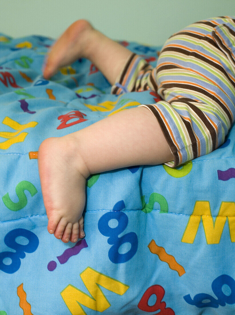 Baby’s feet on an alphabet blanket